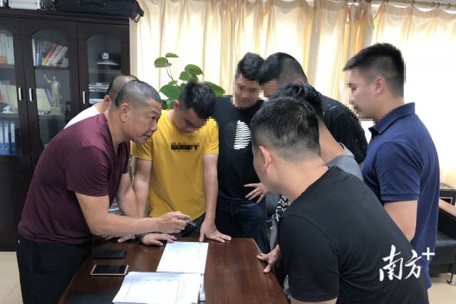 顏海龍（左一）與同事研究抓捕計(jì)劃。
